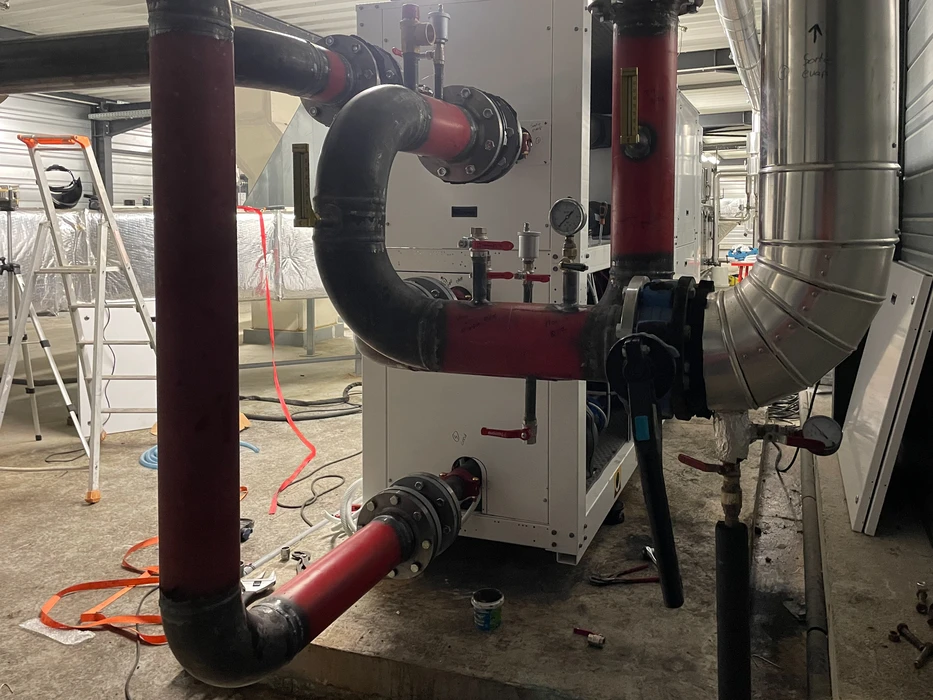 Salle technique industrielle avec équipements de chauffage en cours d'installation