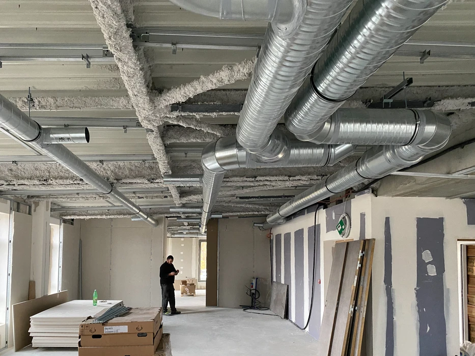Salle de bain moderne avec baignoire encastrée, paroi de douche en verre, vasque noire sur meuble suspendu en bois