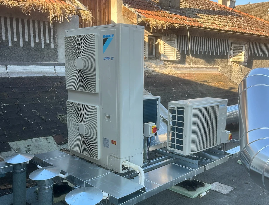 Salle de bain moderne avec baignoire encastrée, paroi de douche en verre, vasque noire sur meuble suspendu en bois
