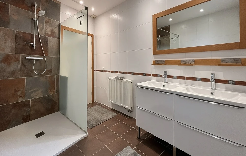 Salle de bain moderne avec douche à l'italienne délimitée par paroi vitrée noire