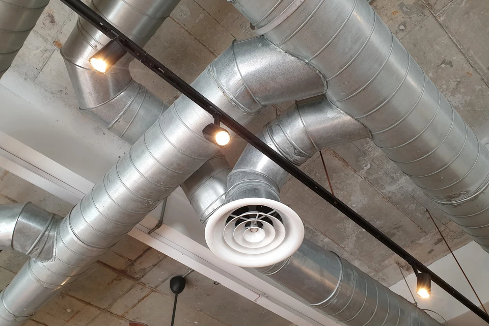 Plafond technique d'un parking souterrain ou garage commercial avec système de ventilation apparent