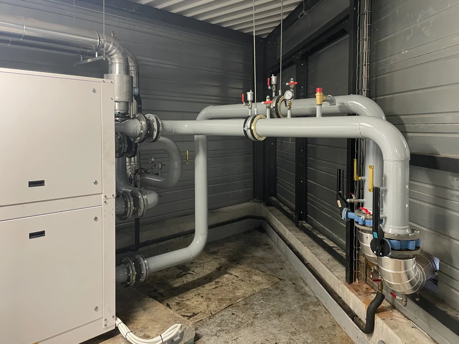 Intérieur d'un local technique avec canalisations de plomberie