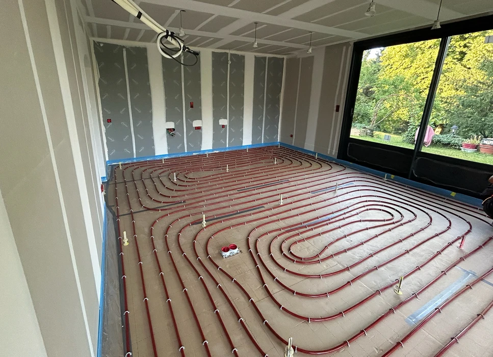 Salle de bain moderne avec baignoire encastrée, paroi de douche en verre, vasque noire sur meuble suspendu en bois